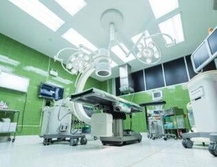A big operation theater after a hospital cleaning job with almost all the operation equipment and light with beautiful green walls