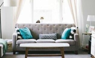 A deep clean sofa with some pillows on it and a table in a room