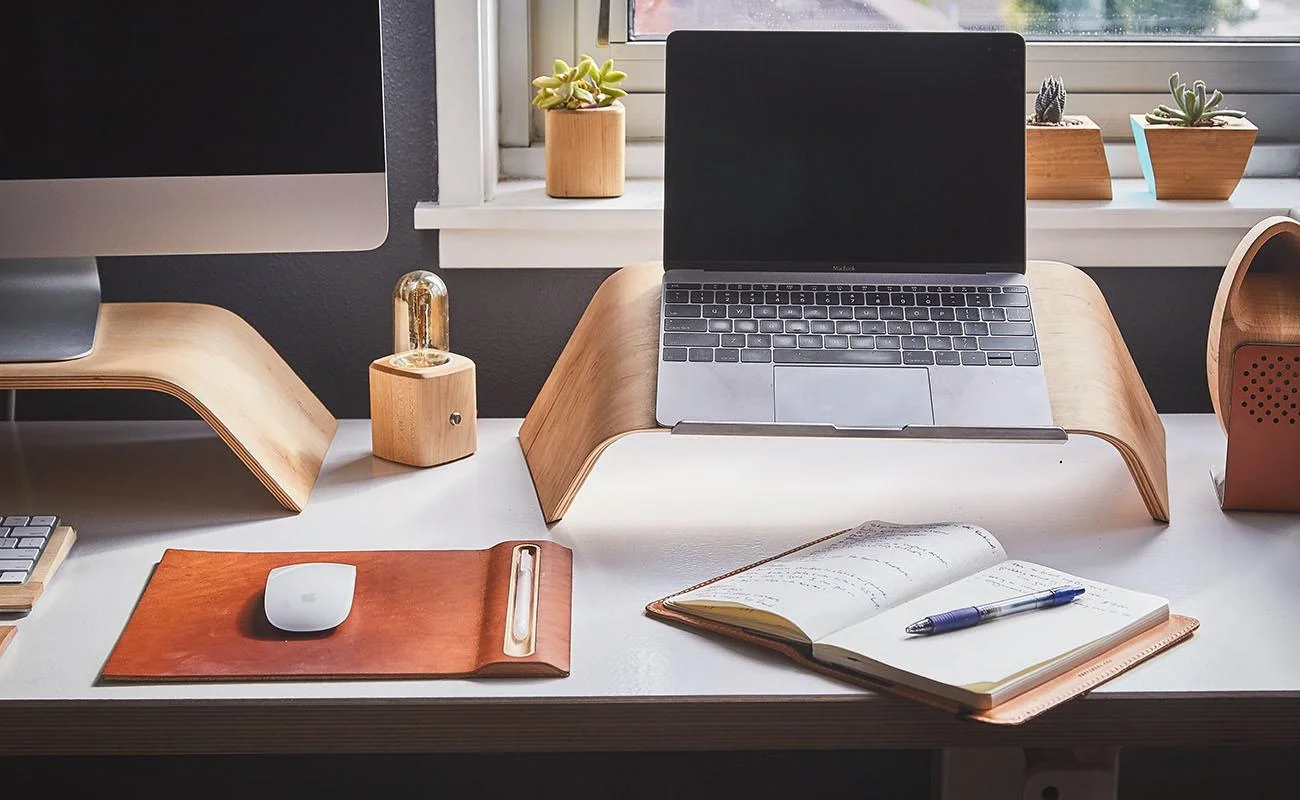 Office Deep Cleaning Service - Kingston London | OnCleaning Deep clean office in London with a MacBook on a laptop table and with an open diary with pen on it and some other decorative stuff