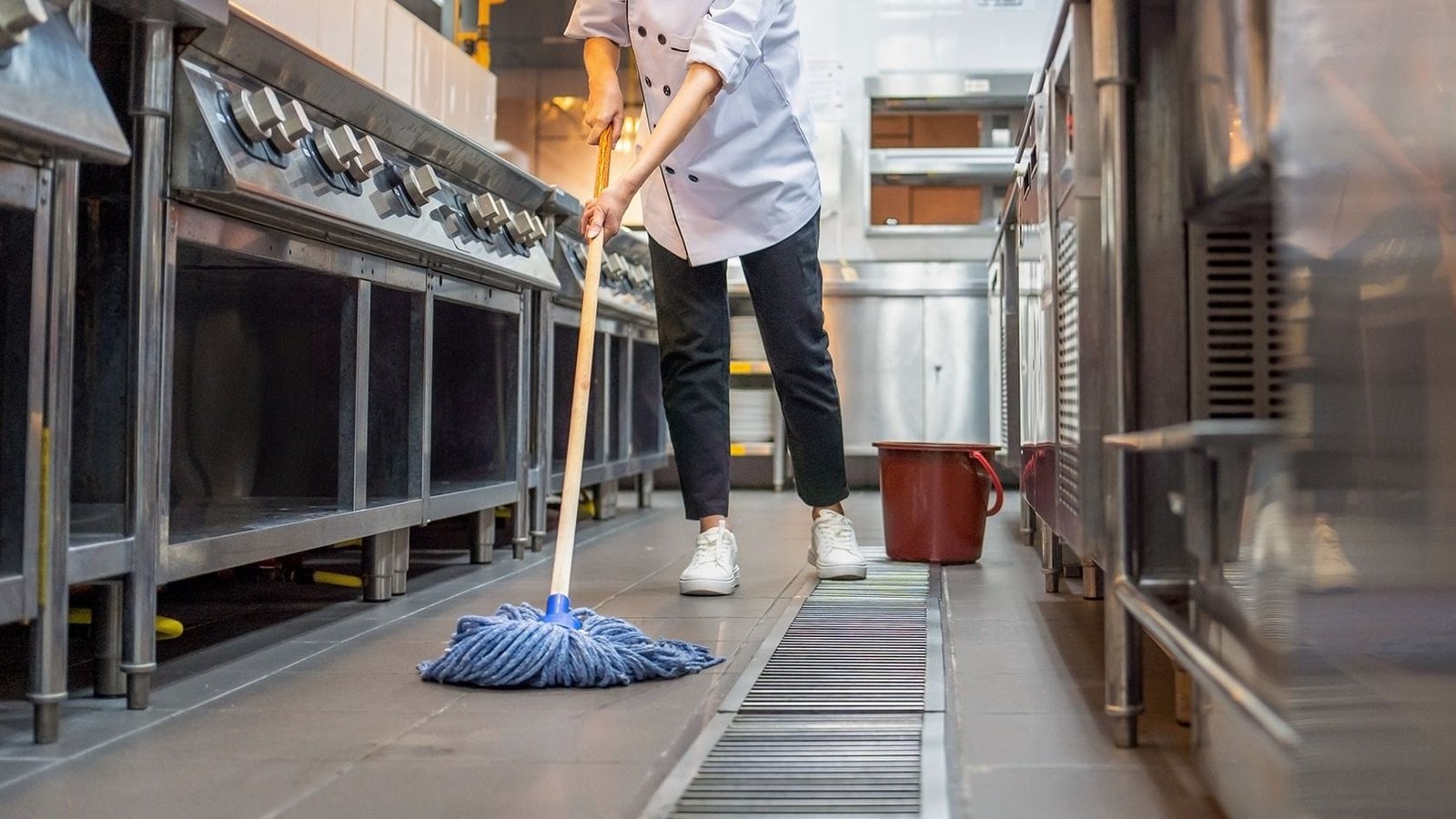 Professional Kitchen Deep Cleaning in Southampton A professional cleaner mopping the floor of a commercial kitchen in Southampton, emphasizing hygiene and deep cleaning standards.